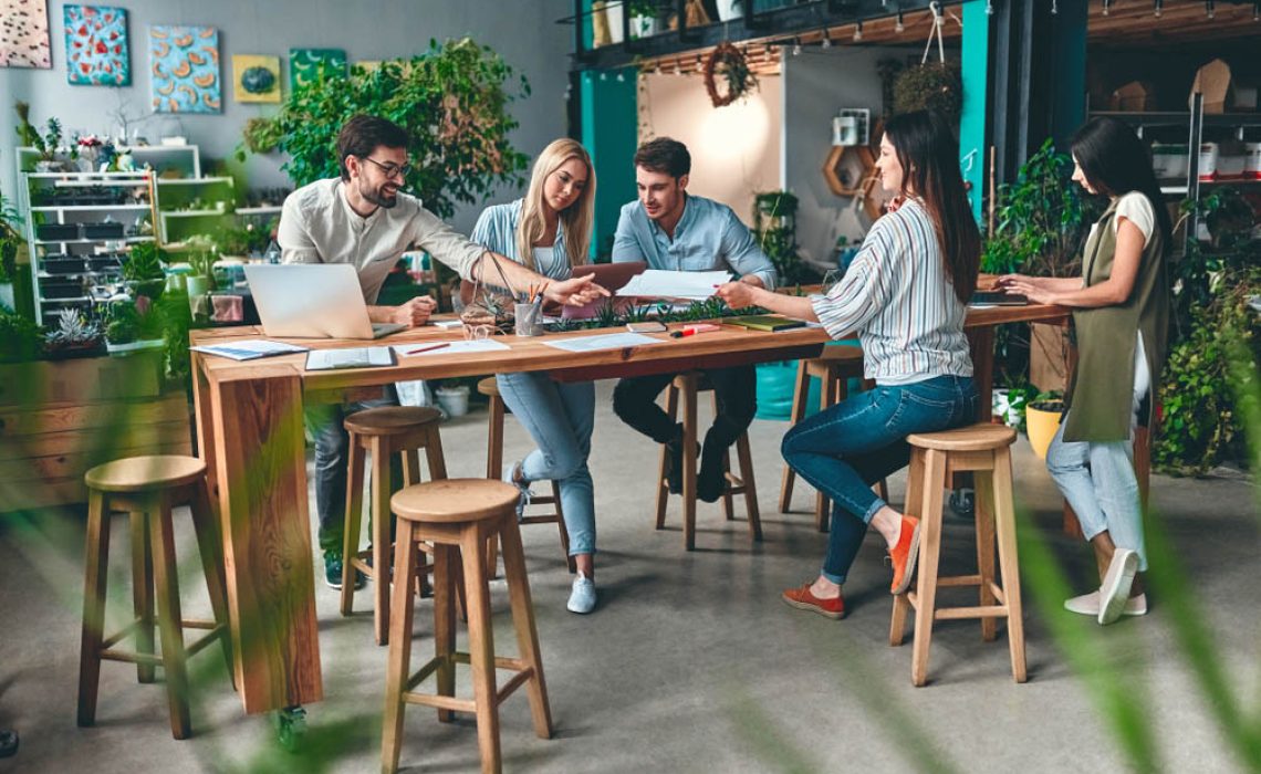 Group of young business people are working together in modern office. Creative people with laptop, tablet, smart phone, notebook. Successful hipster team in coworking. Freelancers.